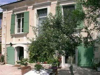 Façade d'une maison d'hôtes provençale aux volets verts